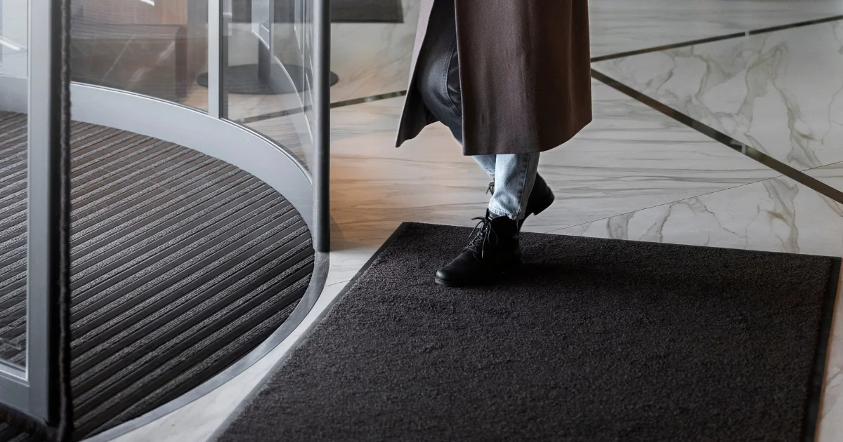 Person walking over a building entrance mat